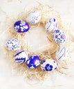 Easter egg wreath on a white wooden background. Royalty Free Stock Photo