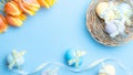 Easter eggs background. Colorful egg with tape ribbon spring tulips feathers on pastel blue background in Happy Easter Royalty Free Stock Photo