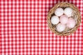 Easter eggs background. Top view on a wicker basket with colorful easter eggs on a red tablecloth or napkin. Decoration background Royalty Free Stock Photo