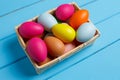 Easter eggs in the basket on blue wooden background