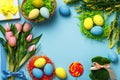 Easter eggs in a basket bouquet of tulips twigs bunny flowers on a blue background Royalty Free Stock Photo