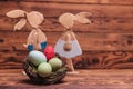 Easter eggs basket in front of wooden rabbits Royalty Free Stock Photo