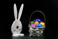 Easter Eggs in Basket with rabbit on black background Royalty Free Stock Photo