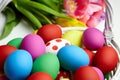 Easter eggs in basket and spring colorful flowers on white wooden table Royalty Free Stock Photo