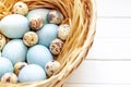 Easter eggs in the basket on a white wooden table