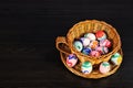 Easter eggs in the basket. wicker basket of straw. festive meal on a dark wooden table Royalty Free Stock Photo