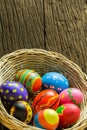 Easter eggs in basket and wood background Royalty Free Stock Photo