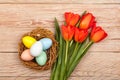 Easter Eggs in a birds nest with colorful tulips Royalty Free Stock Photo