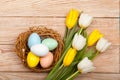 Easter Eggs in a birds nest with colorful tulips Royalty Free Stock Photo