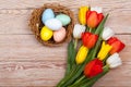 Easter Eggs in a birds nest with colorful tulips Royalty Free Stock Photo