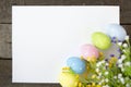 Easter eggs and blank note on wooden background Royalty Free Stock Photo