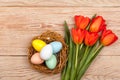 Easter Eggs in a birds nest with colorful tulips Royalty Free Stock Photo