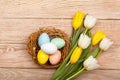 Easter Eggs in a birds nest with colorful tulips Royalty Free Stock Photo