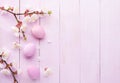 Easter eggs and branches of blossoming Apricot on an old pink wooden table. Flat lay