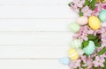 Easter eggs and cherry blossom flowers side border against a white wood background Royalty Free Stock Photo