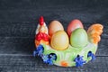 Easter eggs on a colorful chicken-shaped plate, on a wooden background Royalty Free Stock Photo