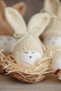 Easter eggs in crochet knitted hats with rabbit ears in nest. Easter celebration concept Royalty Free Stock Photo