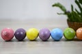 Easter eggs on Easter day background with colorful Eastereggs lined up, rattan basket decoration on white wooden table background. Royalty Free Stock Photo
