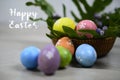 Easter eggs on Easter day. Happy Easter text on background of colorful eggs on wooden rattan basket. Happy Easter Day concept