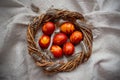 Easter Eggs Decorated with Natural Fresh Leaves and Boiled in Onions Peels on gray linen tablecloth in a wreath. Happy Easter conc Royalty Free Stock Photo