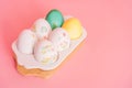 Easter eggs of different colors and in stickers in a white tray on a pink background Royalty Free Stock Photo