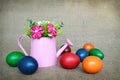 Easter eggs and fabric flowers arranged in watering bucket