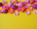 Easter eggs and flowers made of paper on a yellow background. The colors are pink, burgundy, fuchsia and yellow. Spring.