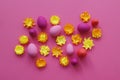 Easter eggs and flowers made of paper on a yellow background. The colors are pink, burgundy, fuchsia and yellow. Spring.