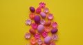 Easter eggs and flowers made of paper on a yellow background. The colors are pink, burgundy, fuchsia and yellow. Spring.