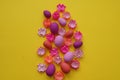 Easter eggs and flowers made of paper on a yellow background. The colors are pink, burgundy, fuchsia and yellow. Spring.