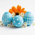 Easter eggs and flowers on white background blue decorated eggs and orange flower with small white blossoms Royalty Free Stock Photo