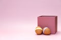 Easter eggs in front of pink square box on empty background Royalty Free Stock Photo