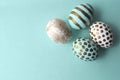 Pretty Easter eggs with gold polka dots and stripes on aqua teal mint background with copy space