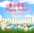 Easter eggs on a grass field with flower on wooden white fence background Royalty Free Stock Photo