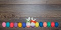 Easter eggs hand painted with knitted bunny hats over wooden background with copy space . Happy Easter