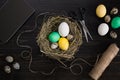 Easter eggs in nest, scissors and thread on a black background Royalty Free Stock Photo