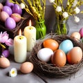 easter eggs in a nest with spring flowers and burning candles on grey background