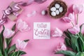 Easter eggs in nest and tulips flowers on pink background with Easter card. Royalty Free Stock Photo