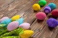 Easter eggs painted in different colors lie on the textured wooden surface in the upper right corner of the frame. Tulips made of Royalty Free Stock Photo