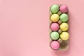 Easter eggs painted in pastel colors in cardboard box on pink background. Space for text