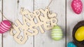 Easter eggs painted in pastel colors on the nest with text happy easte on white wooden background. Easter concept Royalty Free Stock Photo