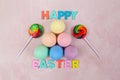 Easter eggs painted in plain colors and lollies with Happy Easter text.