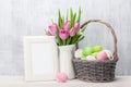 Easter eggs, photo frame and pink tulips Royalty Free Stock Photo