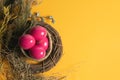 Easter Eggs Pink On Yellow Background With Spoon And Fork And Dried Grass With Wood