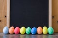 Easter eggs placed in a row with a slate background