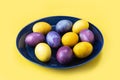 Easter eggs on a plate, on a yellow background. Concept. Painted eggs. Royalty Free Stock Photo