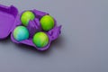 Easter eggs in a purple cardboard egg box on a gray background for the Easter holiday. Copy space Royalty Free Stock Photo