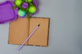 Easter eggs in a purple cardboard egg box with a notebook and pencil on a gray background for the Easter holiday. Copy Royalty Free Stock Photo
