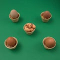 Easter eggs ready in small ice cream cones on a green background. Minimal before the Easter scene
