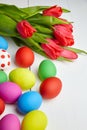Easter Eggs and red tulip flowers on white wooden table Royalty Free Stock Photo